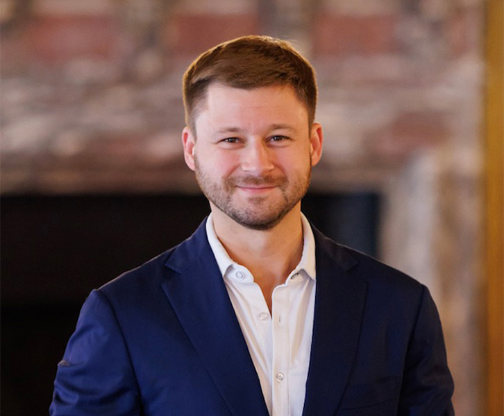 A man smiles in a suit