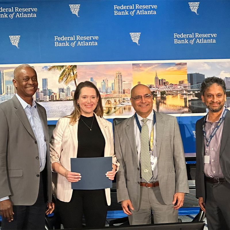 Three men and one woman at the 2025 Household Finance Conference