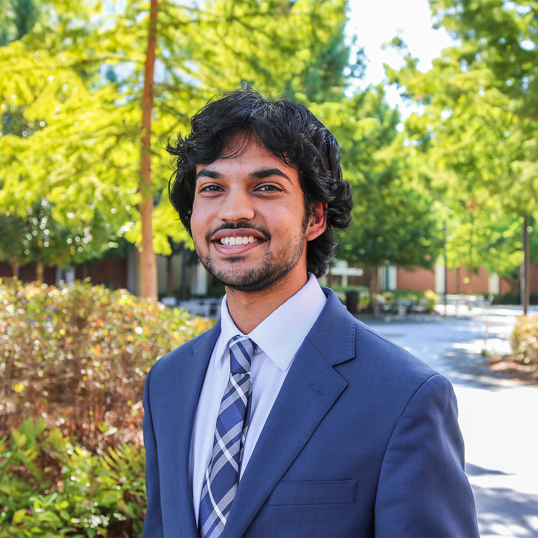 A person smiling in a suit 