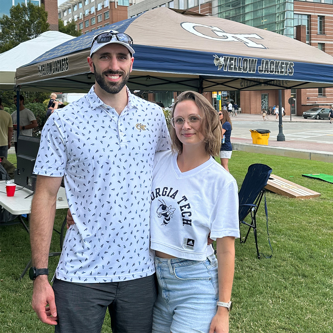 A man stands by a Georgia Tech pop-up tent with his wife 