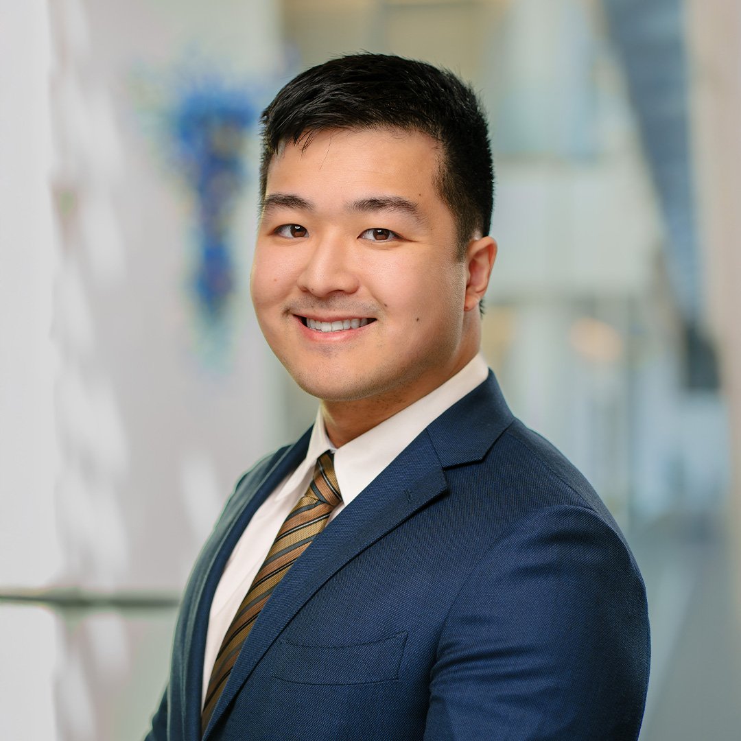 Daniel Yue smiles in a blue suit jacket