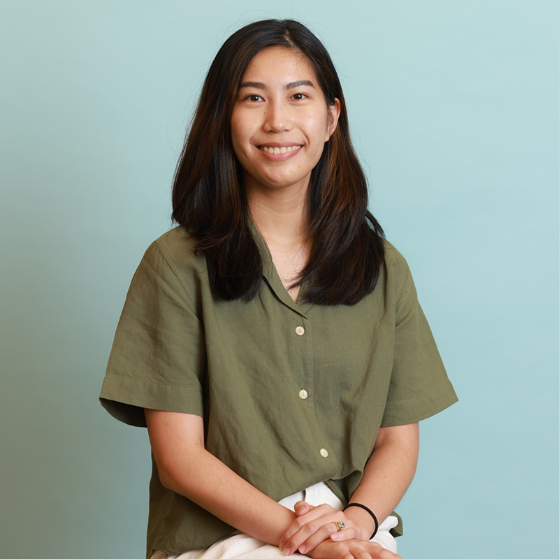 Full-time MBA student Janice Jean sits in front of a blue backdrop