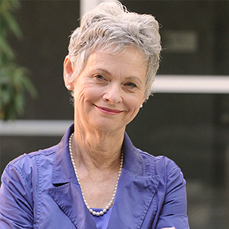 Dr. Marie Thursby smiles wearing a blue suit jacket and pearls