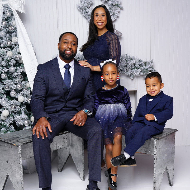 Josef Dorsey smiles in a family portrait with his wife and two children.