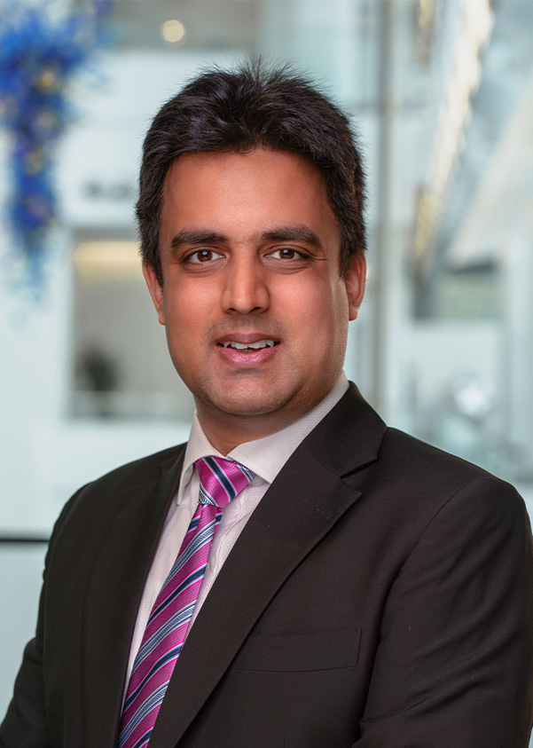 Mustafa Zaidi, Full-time MBA '27 smiles in a suit and tie