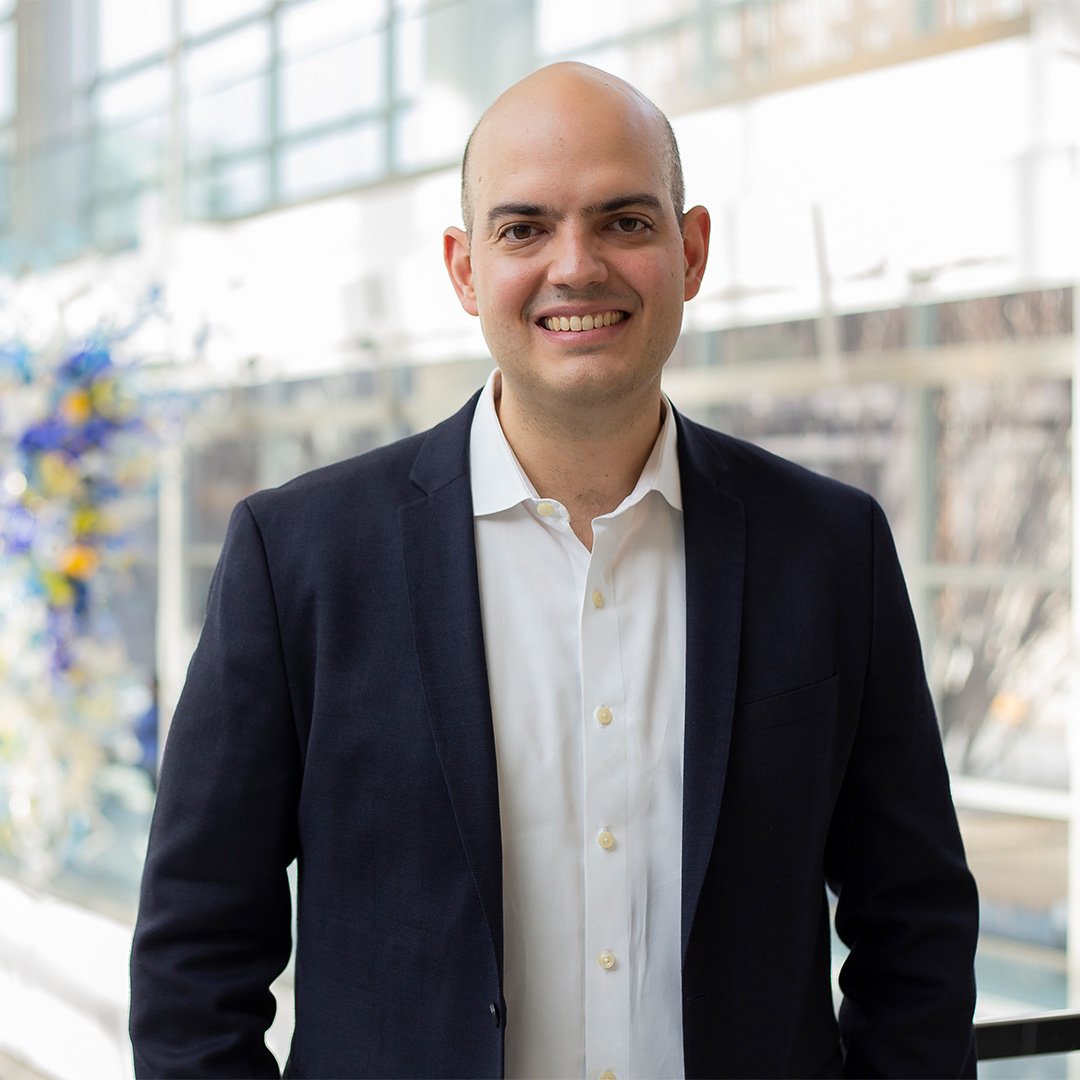 Andre Calmon, associate professor of operations management, smiles wearing a dark suit jacket and white collared shirt.