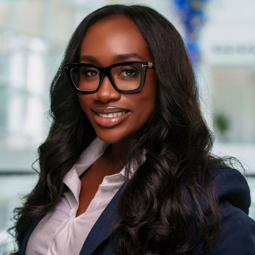 Jamila Moses’ headshot photo; she wears thick-rimmed glasses with a black suit jacket.