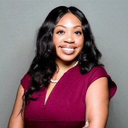 Lauren Bateman smiles wearing a dark pink shirt