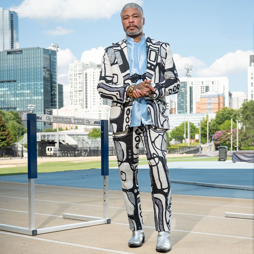 Octavius Terry, BM '96, a Georgia Tech track and field standout poses on the track with the Atlanta skyline in the background.