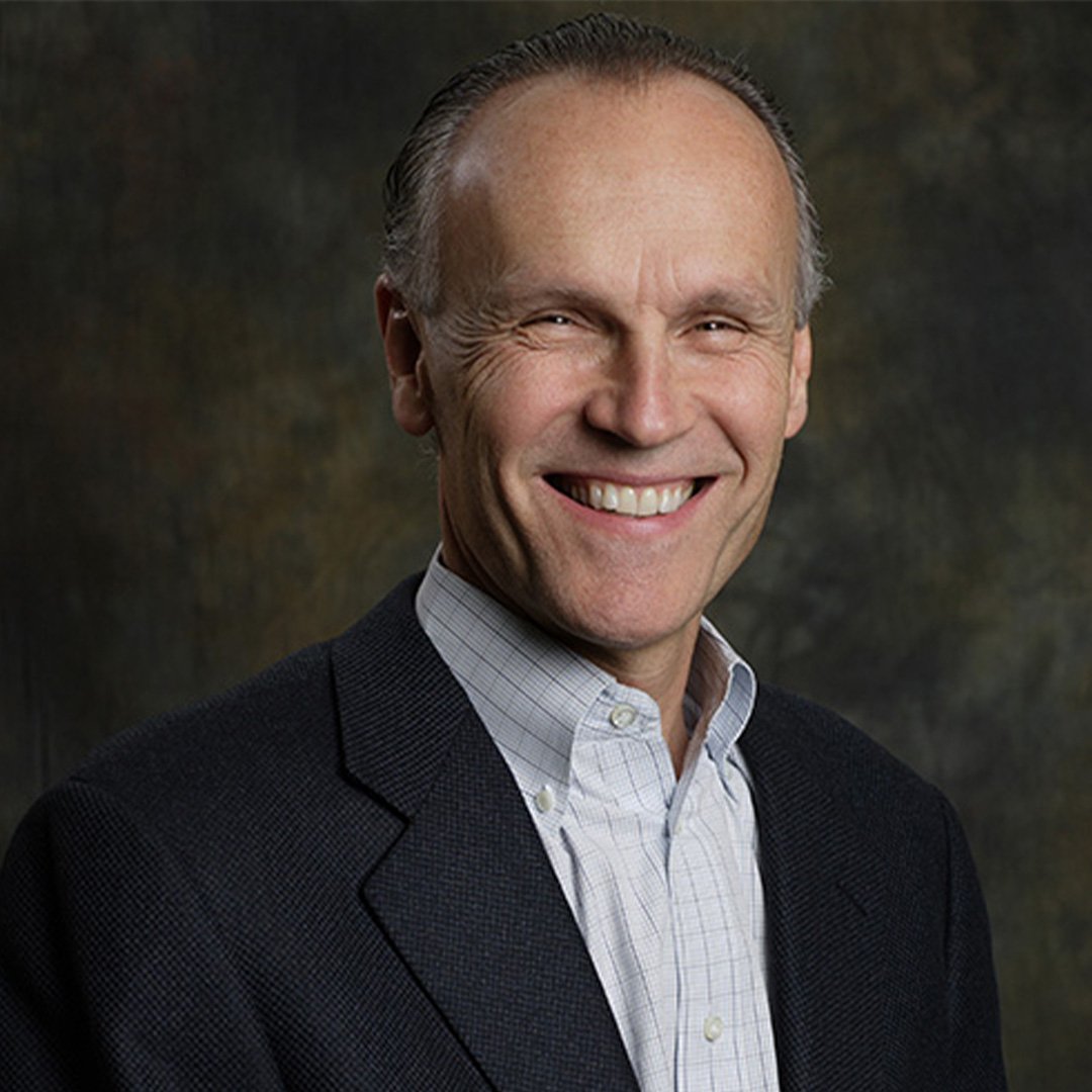 Steven A. Denning smiles in a suit jacket