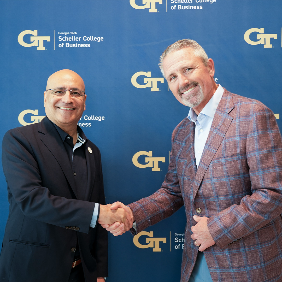 Dean Anuj Mehrotra shakes hands with Jim Hannan, president and COO of Koch at a Tech Talks Business event.