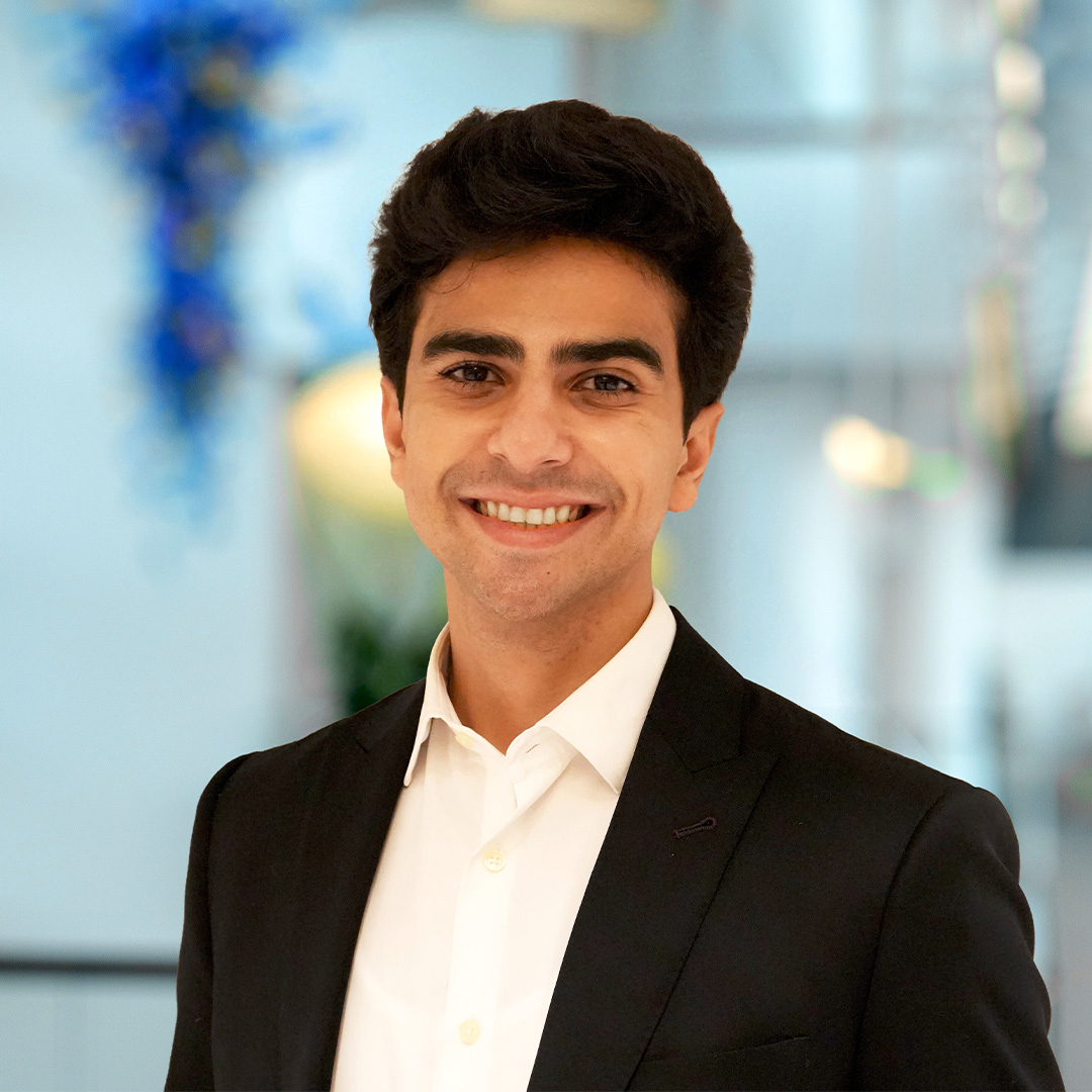 Wajahat Latif, an Evening MBA and TI:GER student dressed in a black suit jacket, smiles for his headshot.