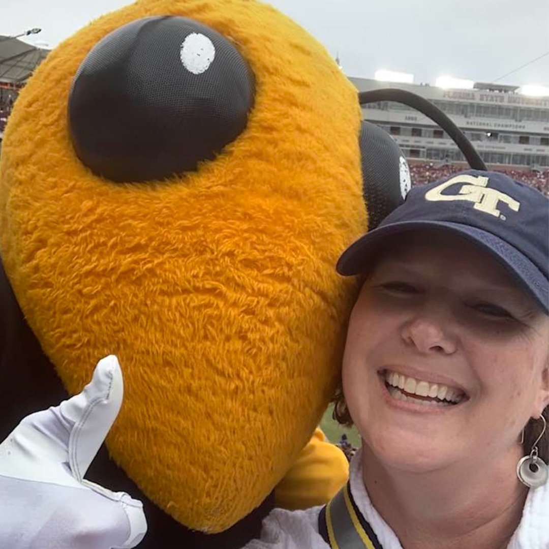 Sissy Blanchard smiles with the Buzz mascot at a Georgia Tech football game.