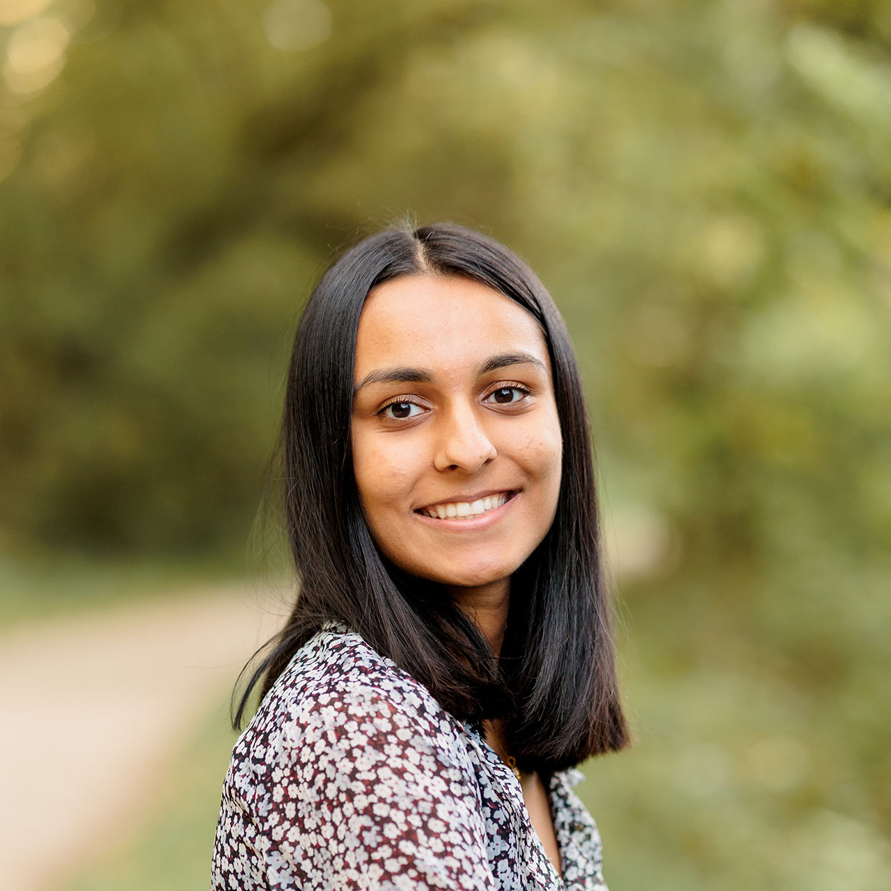 Female student sitting outside looking at the camera