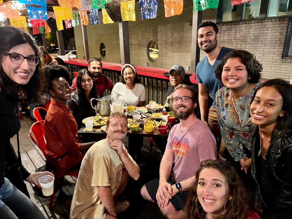 Scheller students sit in a restaurant for a Scheller Pride kick-off event