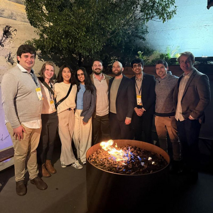 Kjersti Lukens with ClimateCAP attendees standing outside behind a fire