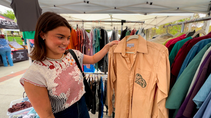 Kate checks out a second-hand shirt at the community market at Tech Walkway.
